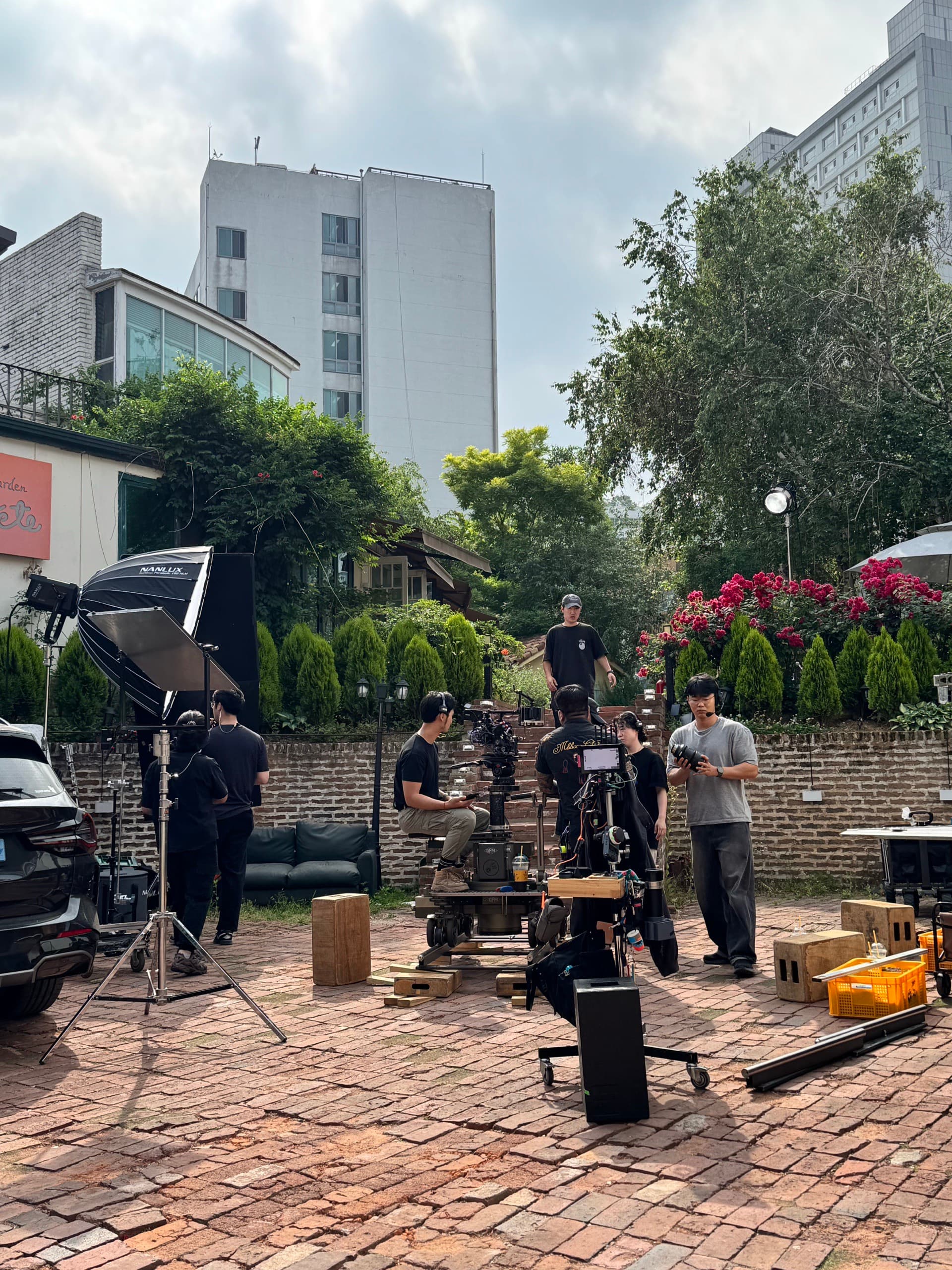 Crew setting up a shot in a brick courtyard location in Seoul